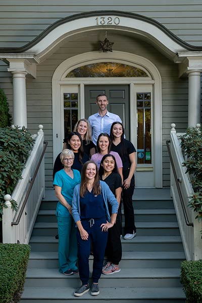 Team at Meadowlark Dental standing on the stairs of the office building in Salem, OR.